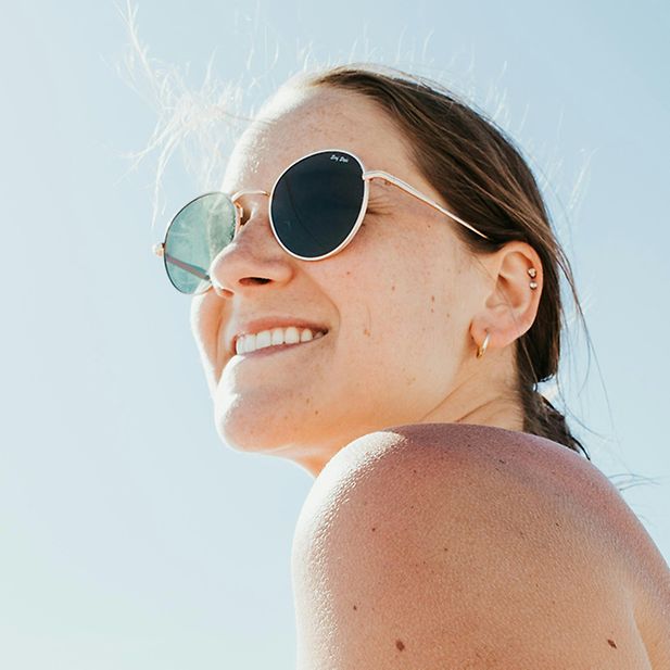 Lachende vrouw met zonnebril op een zonnige dag