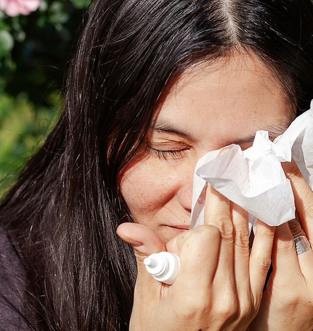 Vrouw dept voorzichtig haar ogen met een tissue na het gebruiken van oogdruppels 