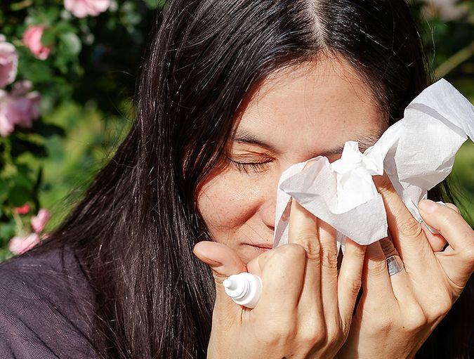 Vrouw dept voorzichtig haar ogen met een tissue na het gebruiken van oogdruppels