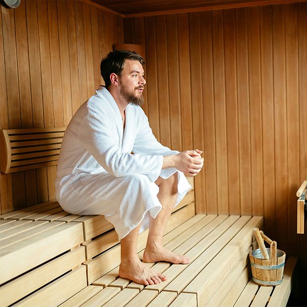 Man ontspant in een sauna, omringd door stoom