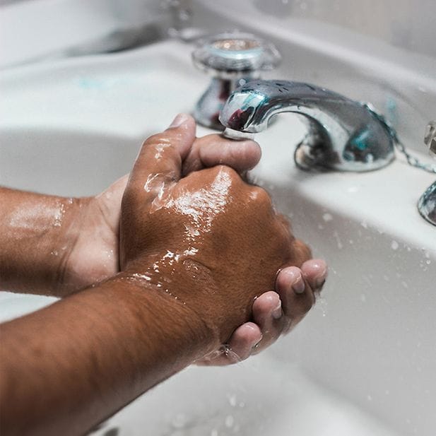 Close-up van iemand die zijn of haar handen wast. 