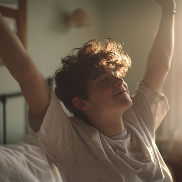 Jongen die wakker wordt en zijn armen uitstrekt